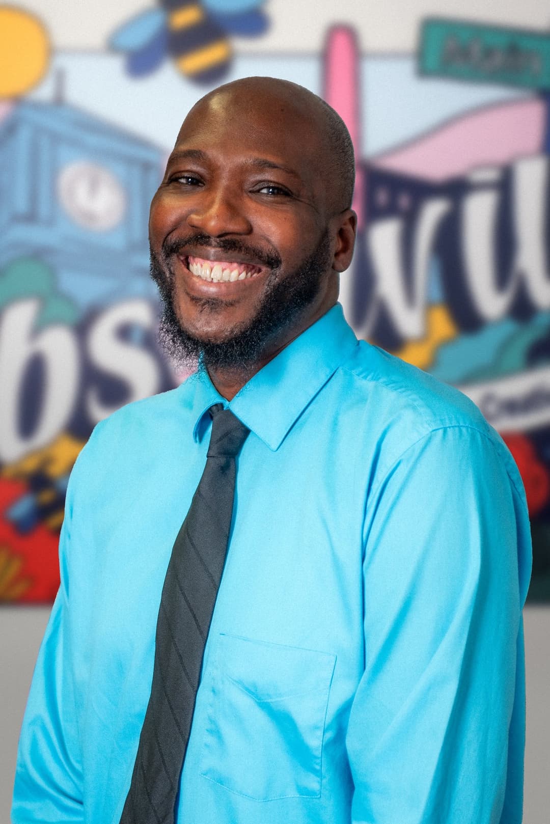 Bryant Crisp standing next to a mural.